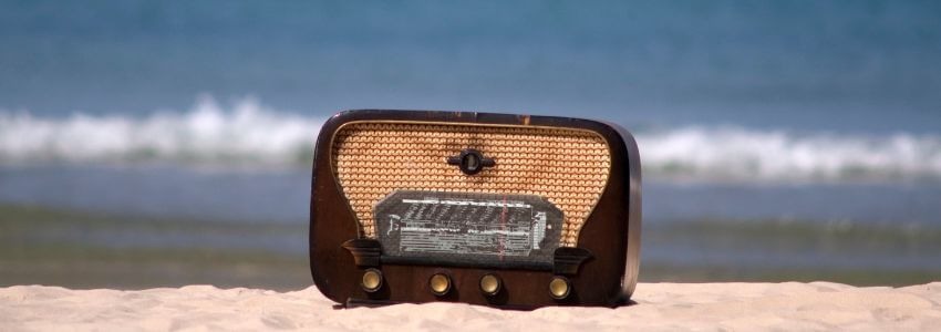 Strandradio auf dem Sand mit Blick aufs Meer.